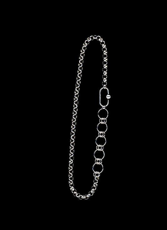Stainless steel chain necklace with orbit carabiner and chainmail detail on a black background