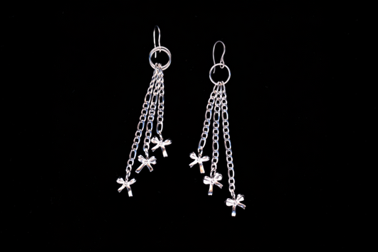 A pair of stainless steel chain-drop bow earrings with multiple small bows attached to figaro chains, displayed against a black background.