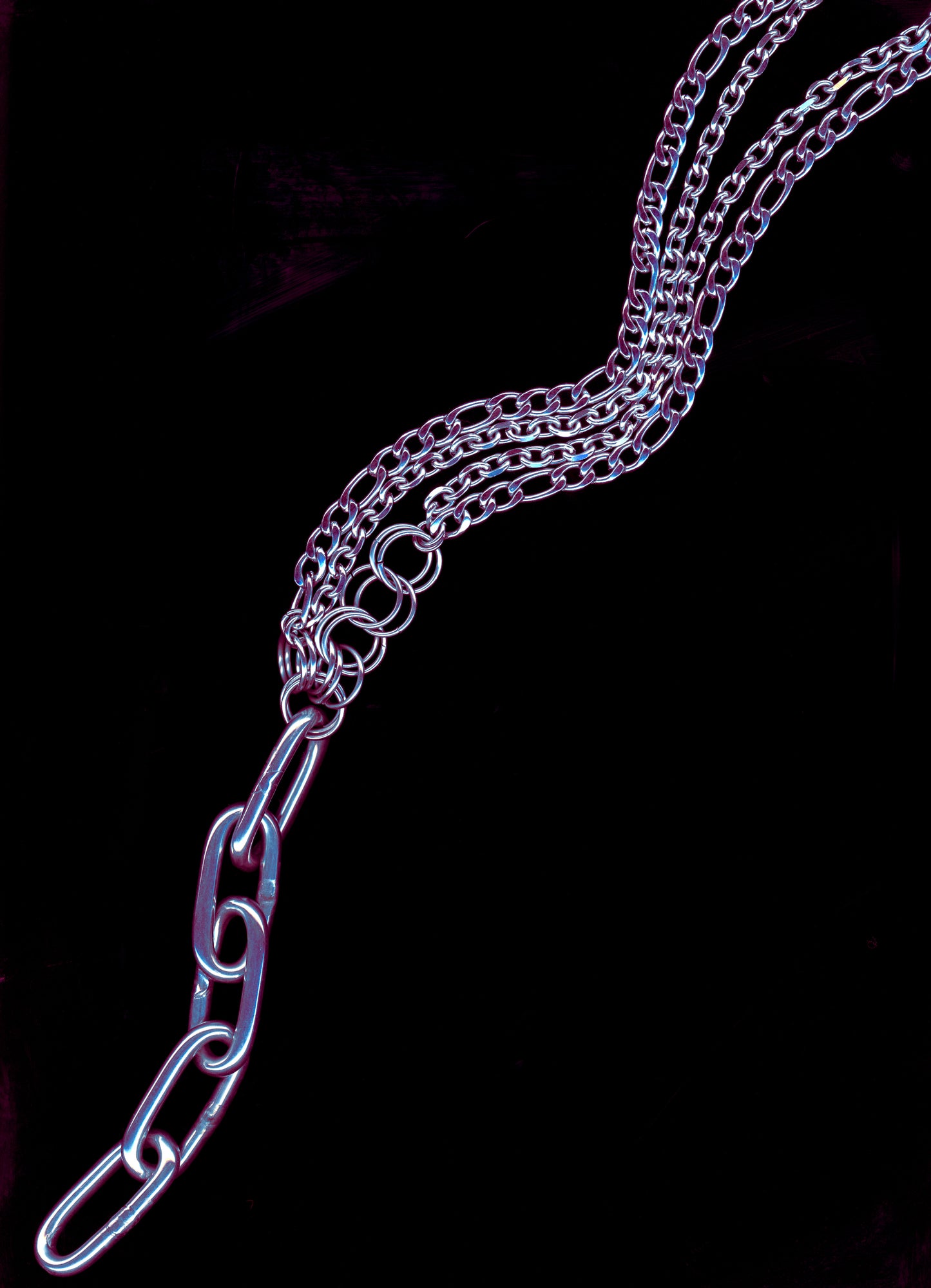 A silver Figaro chain lariat necklace with a diamond-cut chain pendant and chainmail detail, displayed against a black background.