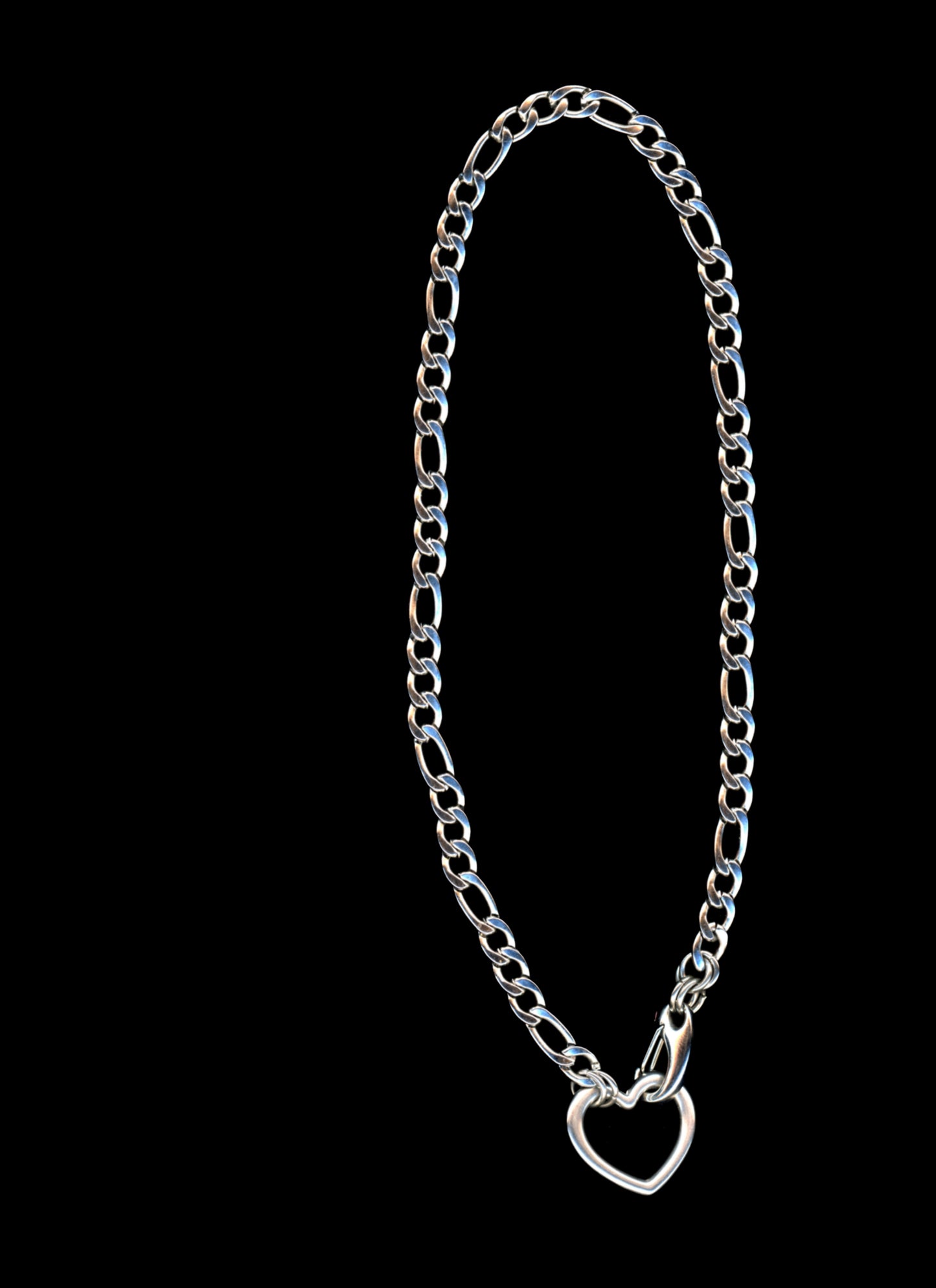 Silver chain necklace with a heart-shaped closure on a black background