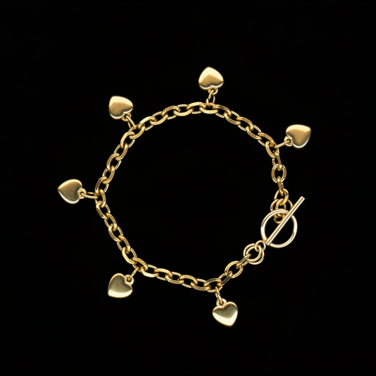 Gold bracelet with heart-shaped charms on a black background
