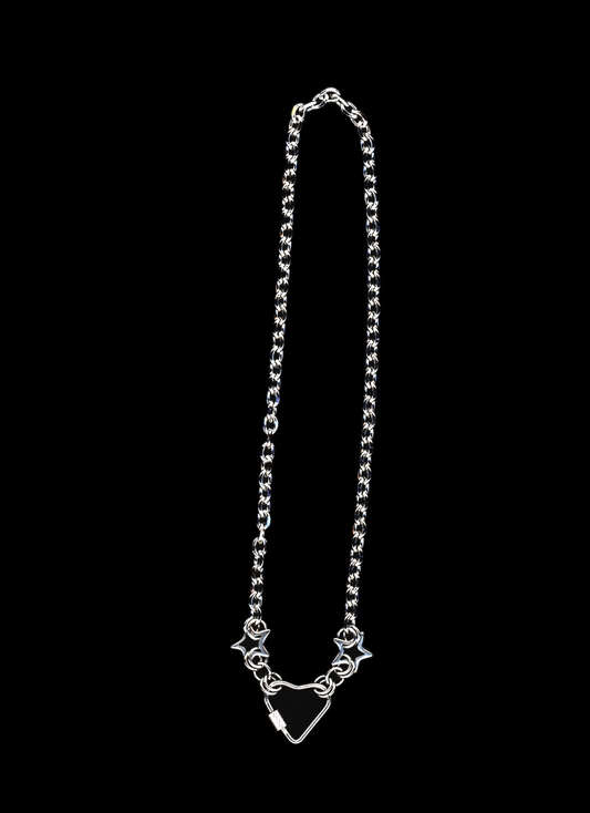 Stainless steel chain necklace with a heart carabiner closure surrounded by two chainmail stars on a black background