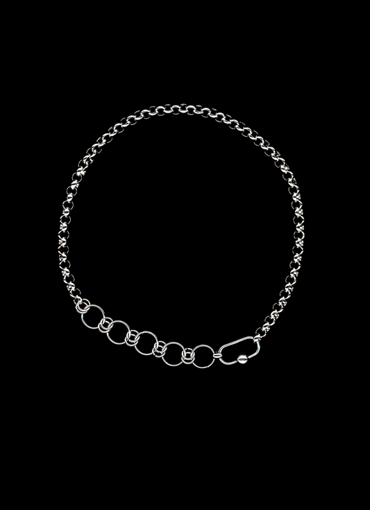 Stainless steel chain necklace with orbit carabiner and chainmail detail on a black background