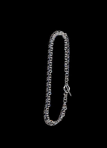 Stainless steel chain necklace with double chain strand and organic toggle closure on a black background