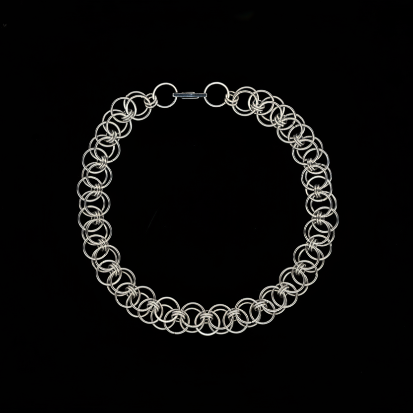 Silver chainmail necklace on a black background