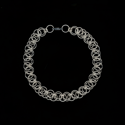 Silver chainmail necklace on a black background