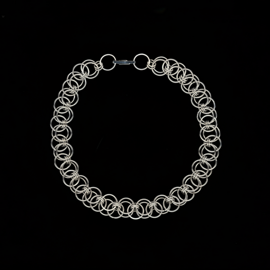 Silver chainmail necklace on a black background