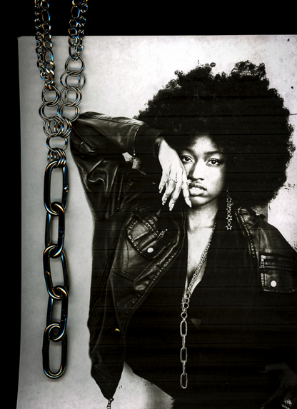 black and white photocopy scan edit of person with large afro and chain necklace against a plain background with the same chain overlayed in the scan.