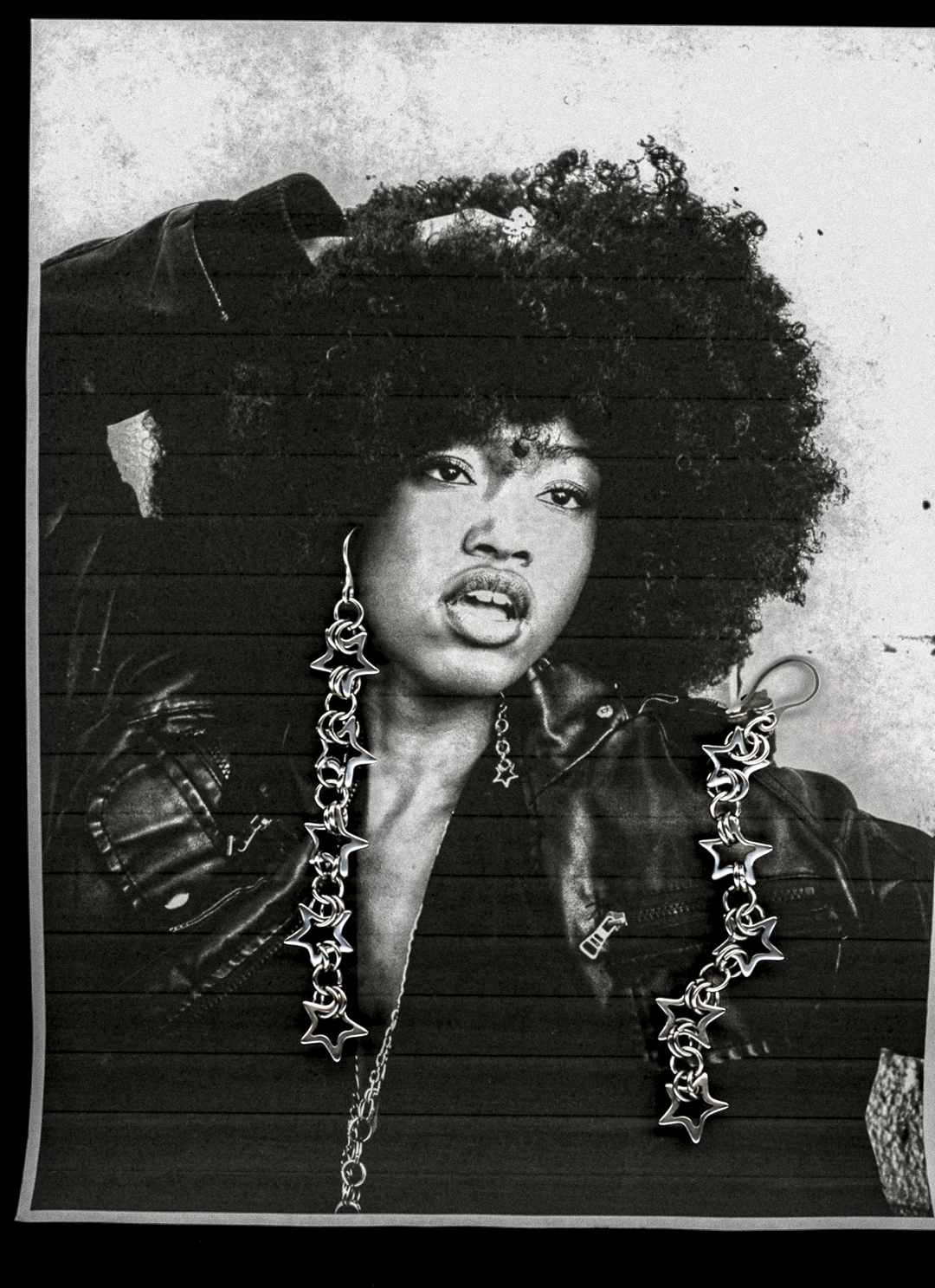 Black and white portrait of a person wearing large, star-shaped earrings.