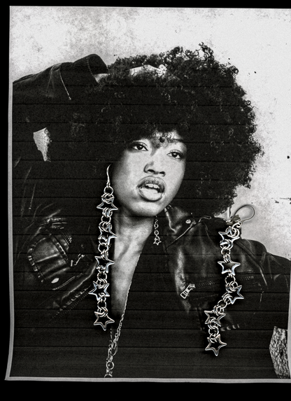 Black and white portrait of a person wearing large, star-shaped earrings.