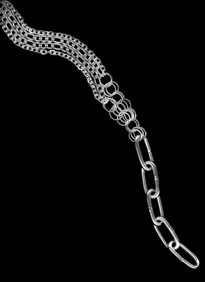 A silver Figaro chain lariat necklace with a diamond-cut chain pendant and chainmail detail, displayed against a black background.