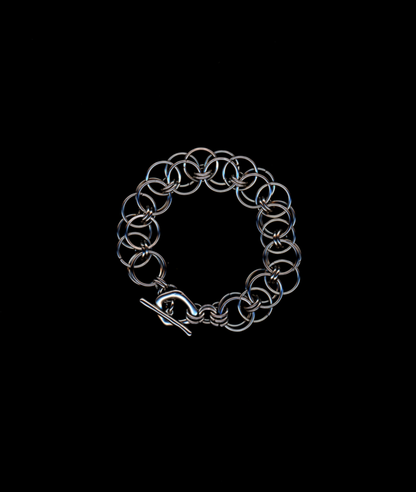 Silver chainmail bracelet on a black background