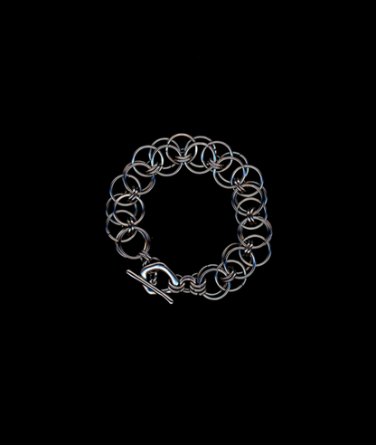 Silver chainmail bracelet on a black background