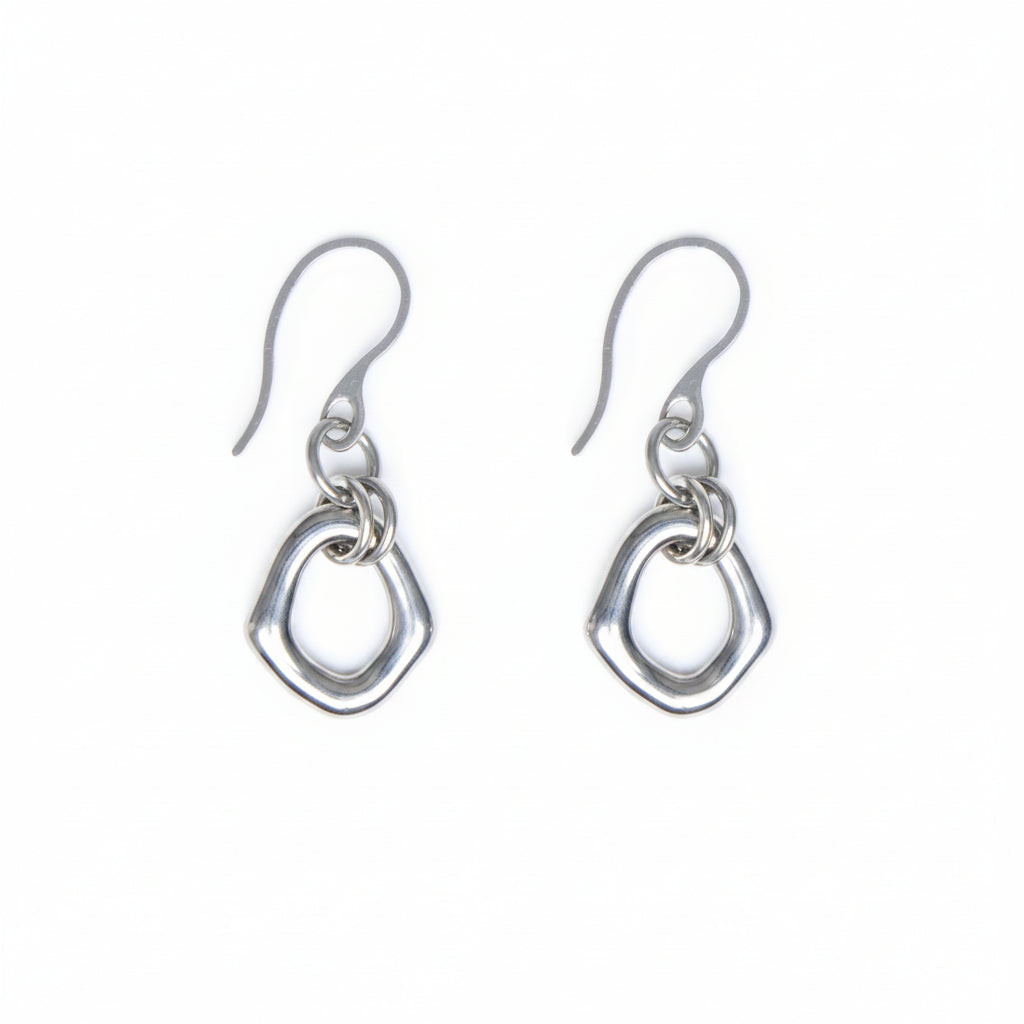 Pair of organic oval stainless steel, silver toned earrings with a french hook on a white background