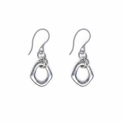 Pair of organic oval stainless steel, silver toned earrings with a french hook on a white background