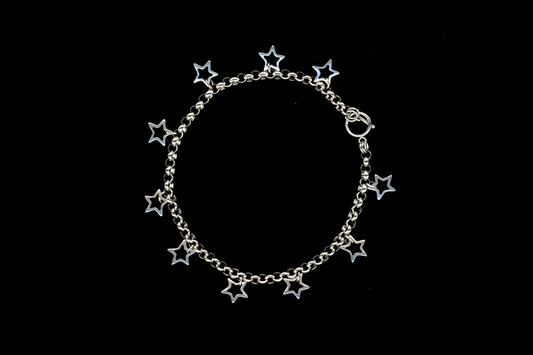 A silver charm necklace with hollow star charms attached to a chunky rolo chain, displayed against a black background.
