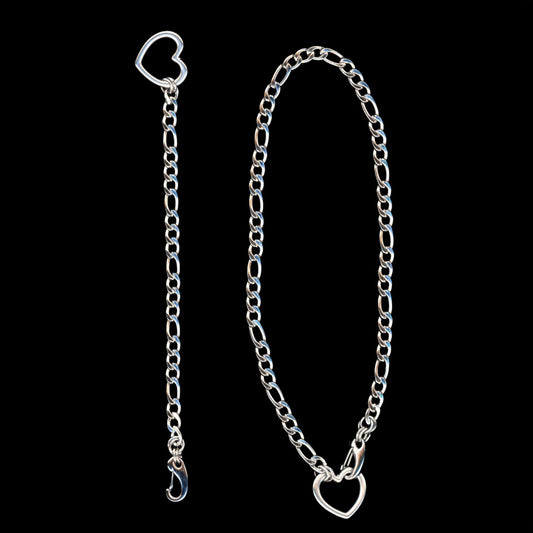 Silver chain necklace and bracelet with heart-shaped closures on a black background