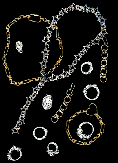 A stainless steel star chainmail necklace with a spring closure clasp, and other bywolfgang chain necklaces, earrings, and bracelets displayed against a black background.