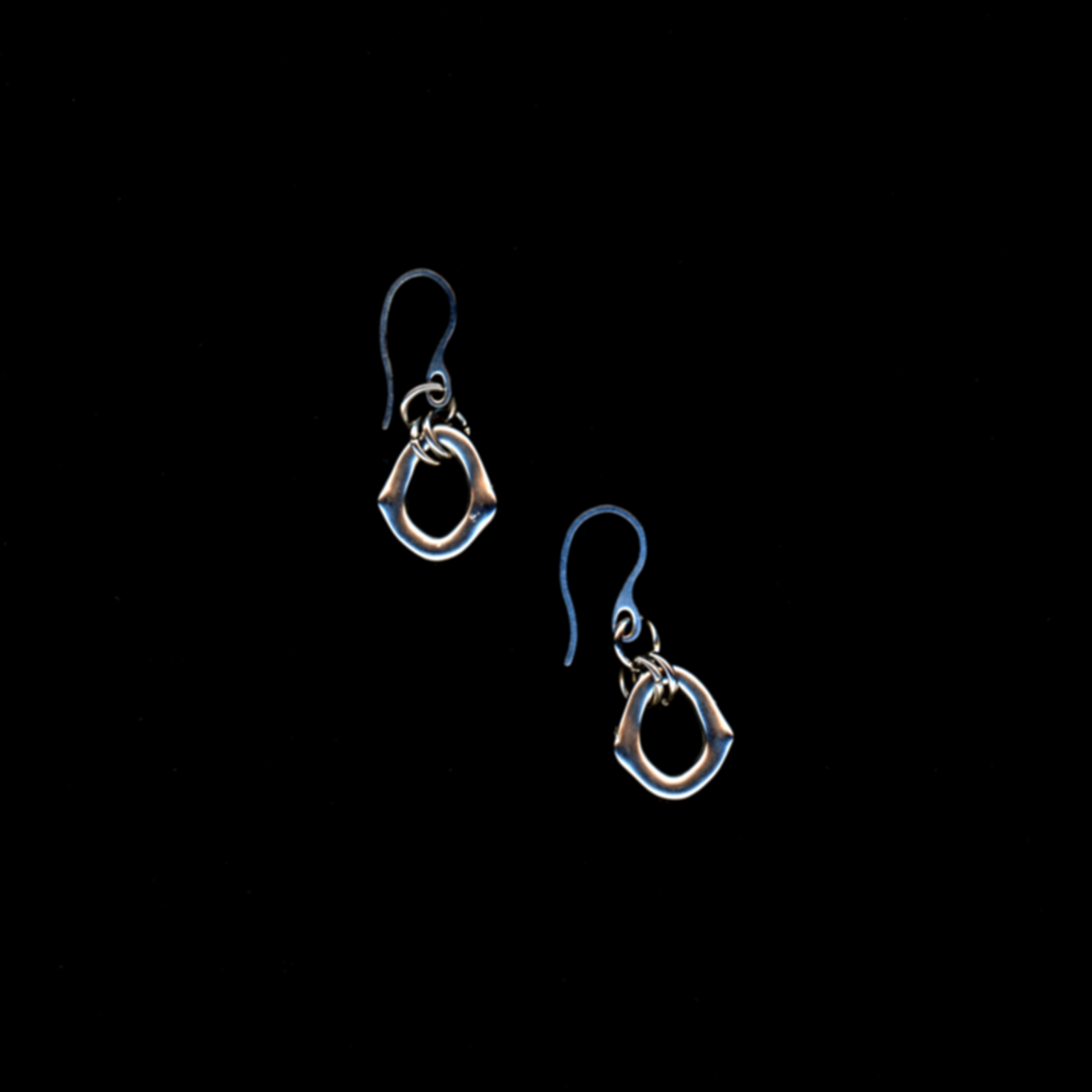 Pair of stainless steel 'portal' earrings on a black background