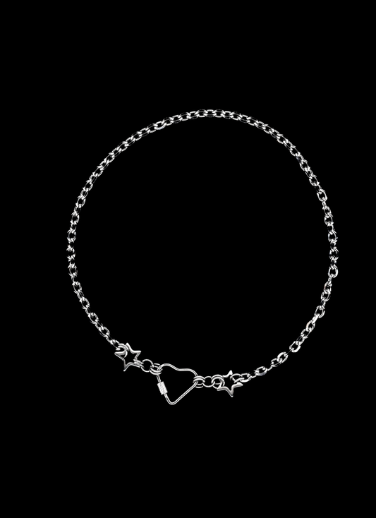 Stainless steel chain necklace with a heart carabiner closure surrounded by two chainmail stars on a black background